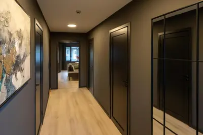 a hallway with black doors and wood floors at Florø Apartments Hotell in Florø