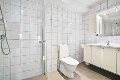 a bathroom with a toilet and a sink and a shower at Florø Apartments Hotell in Florø