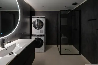 a bathroom with a sink and a washing machine at Florø Apartments Hotell in Florø