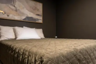 a bedroom with a bed with a painting on the wall at Florø Apartments Hotell in Florø