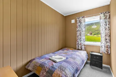 a small bedroom with a bed and a window at Engbu in Vågbø