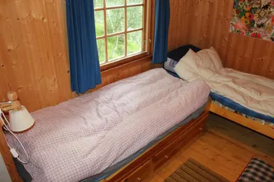 a bedroom with two beds and a window at Jonstølen by Norgesbooking - cabin at 1020 masl in Trondsgard