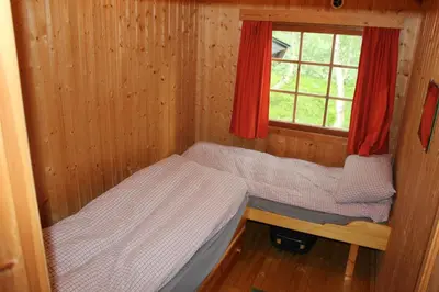 a small cabin with a bed and a window at Jonstølen by Norgesbooking - cabin at 1020 masl in Trondsgard