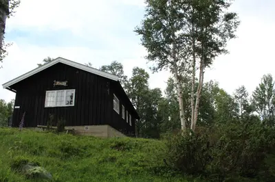 a black house sitting on top of a hill at Jonstølen by Norgesbooking - cabin at 1020 masl in Trondsgard