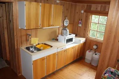 a small kitchen with a sink and a microwave at Jonstølen by Norgesbooking - cabin at 1020 masl in Trondsgard