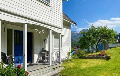 a white house with a porch with a blue door at Cozy Home In Austefjorden With Wifi in Austefjorden