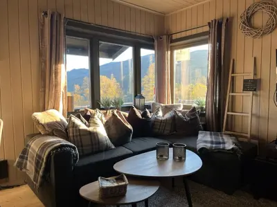 a living room with a couch and a table at Cozy cabin with a view in Kvamseter