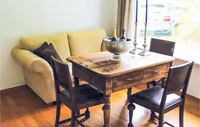 a dining room table with chairs and a couch at 4 Bedroom Nice Home In Eidfjord in Eidfjord