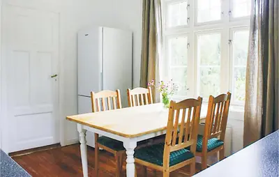 a kitchen with a table with chairs and a refrigerator at 4 Bedroom Nice Home In Eidfjord in Eidfjord