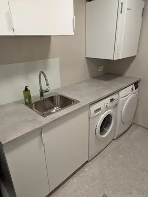 a kitchen with a sink and a washing machine at Flotun in Stryn