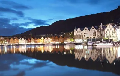 a group of buildings sitting on the water near a harbor at Dreggsalmenning 20 in Bergen