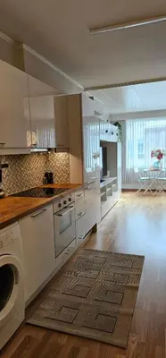 a large kitchen with white cabinets and a stove top oven at Dreggsalmenning 20 in Bergen