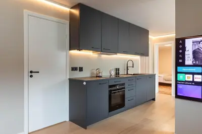 a kitchen with black cabinets and a stove top oven at Huset på Plassen in Sogndal