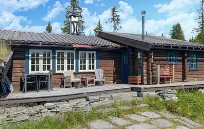a log cabin with a porch and a table and chairs at Awesome Home In Aurdal With Sauna in Aurdal