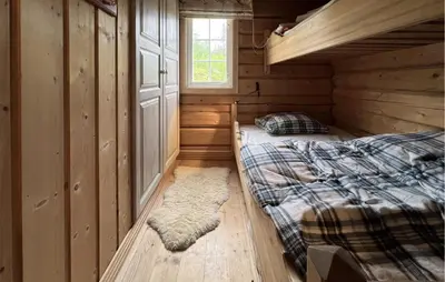 two beds in a log cabin bedroom with a window at Awesome Home In Aurdal With Sauna in Aurdal