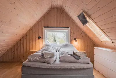 a bed in the middle of a room with a window at Toppleilighet i sentrum av Lillehammer in Lillehammer