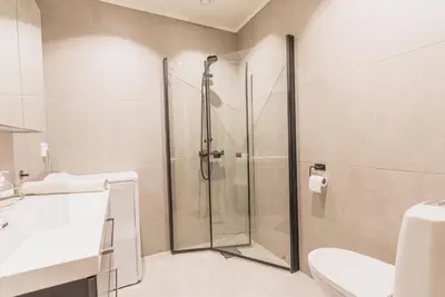 a bathroom with a shower and a toilet and a sink at Toppleilighet i sentrum av Lillehammer in Lillehammer