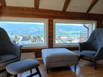 a waiting room with two chairs and two windows at Toppleilighet i sentrum av Lillehammer in Lillehammer
