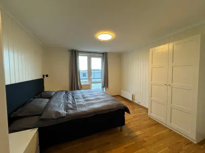 a bedroom with a large bed and a window at Charming 3-Bedroom Apartment in the Heart of Kristiansund in Kristiansund