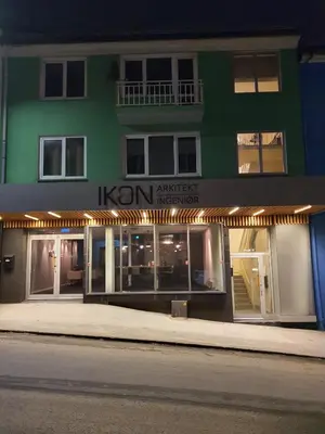 a green building with a sign on the side of it at Charming 3-Bedroom Apartment in the Heart of Kristiansund in Kristiansund