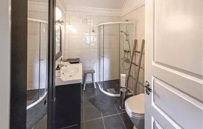 a bathroom with a shower and a sink and a toilet at Feriehus-Bjørkedal in Folkestad