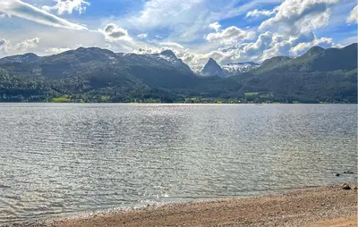 a large body of water with mountains in the background at Feriehus-Bjørkedal in Folkestad