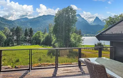 a balcony with a view of a lake and mountains at Feriehus-Bjørkedal in Folkestad