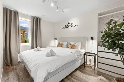 a white bedroom with a large bed and a window at Pergola - Free parking - 5 min walk to facilities in Bergen