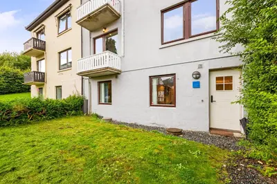 a white house with a yard in front of it at Pergola - Free parking - 5 min walk to facilities in Bergen