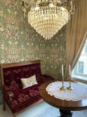 a living room with a chandelier and a table at Jugend 1903 in Ålesund