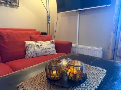 a living room with a couch and a table at Charming Ground-Floor Apartment In Beitostølen With Terrace in Beitostøl