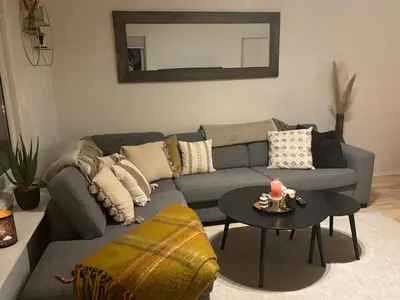 a living room with a couch and a table at Fin leilighet nært alt in Bergen