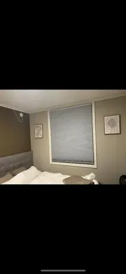 a bedroom with a bed and a window with blinds at Fin leilighet nært alt in Bergen