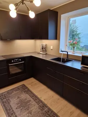 a kitchen with black cabinets and a sink and a window at Eidsvåg in Bergen