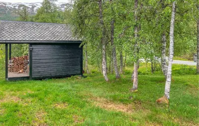 a garage in the grass next to some trees at 3 Bedroom Stunning Home In Vossestrand in Vossestrand