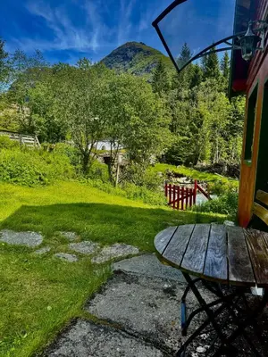 a picnic table in a yard with mountains in the background at Haukedalen mountain panorama river view in Holsen