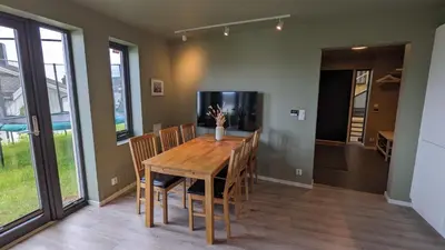 a dining room with a wooden table and chairs at New and fresh apartment, free parking and ocean view in Trondheim
