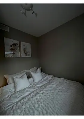 a bedroom with a bed with white sheets and pillows at Penthouse in Trondheim City Centre in Trondheim