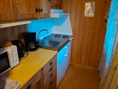 a small kitchen with a sink and a microwave at Kvanndal Camping in Kvanndal