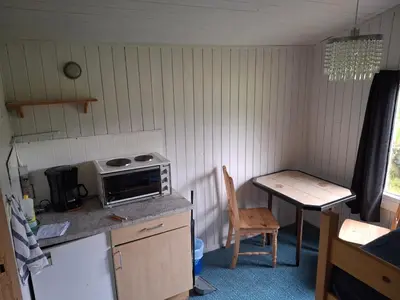 a small kitchen with a table and a microwave at Kvanndal Camping in Kvanndal