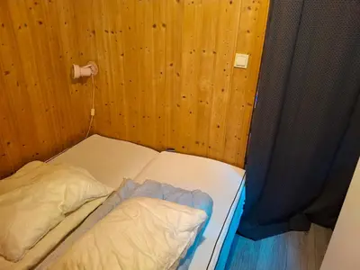 two beds in a room with wood paneled walls at Kvanndal Camping in Kvanndal