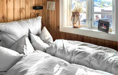 a bed with white sheets and pillows next to a window at 4 Bedroom Cozy Home In Gol in Golsfjellet