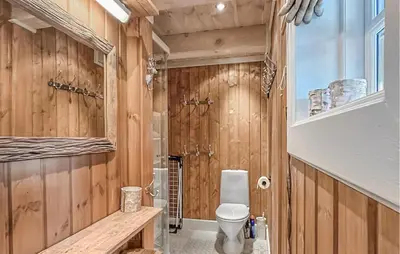 a bathroom with a toilet and wooden walls at 4 Bedroom Cozy Home In Gol in Golsfjellet