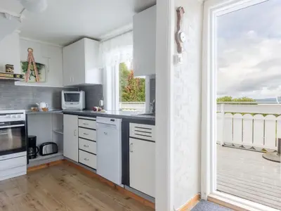 a kitchen with white cabinets and a large window at Holiday Home Soltun by Interhome in Flygansvær
