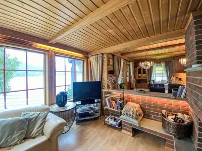 a living room with a couch and a brick wall at Holiday Home Strand by Interhome in Vassenden
