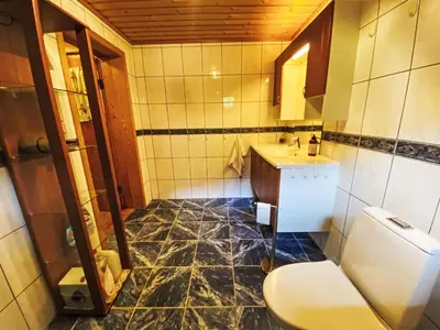 a bathroom with a toilet and a sink at Holiday Home Strand by Interhome in Vassenden