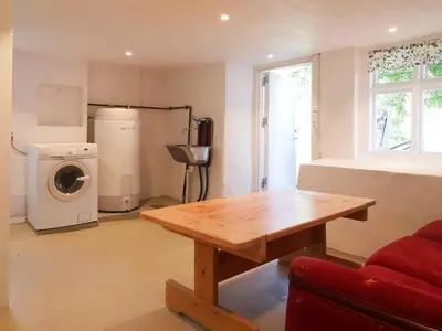 a living room with a wooden table and a washing machine at Holiday Home Greenhouse by Interhome in Onarheim