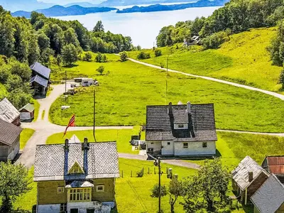 an old house on a hill next to a road at Holiday Home Greenhouse by Interhome in Onarheim