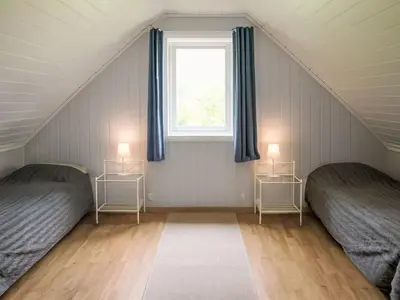 a attic bedroom with two beds and a window at Holiday Home Laksevågen by Interhome in Bruntveit