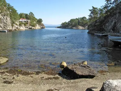 a body of water with a bench on the shore at Holiday Home Laksevågen by Interhome in Bruntveit